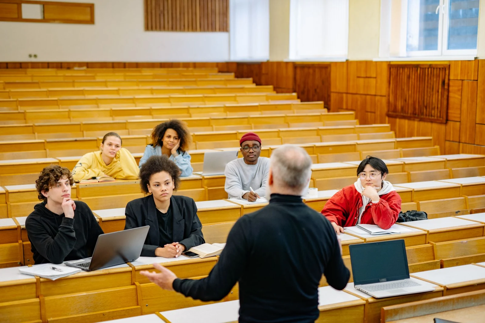 A lecturer addresses students in a university lecture hall.