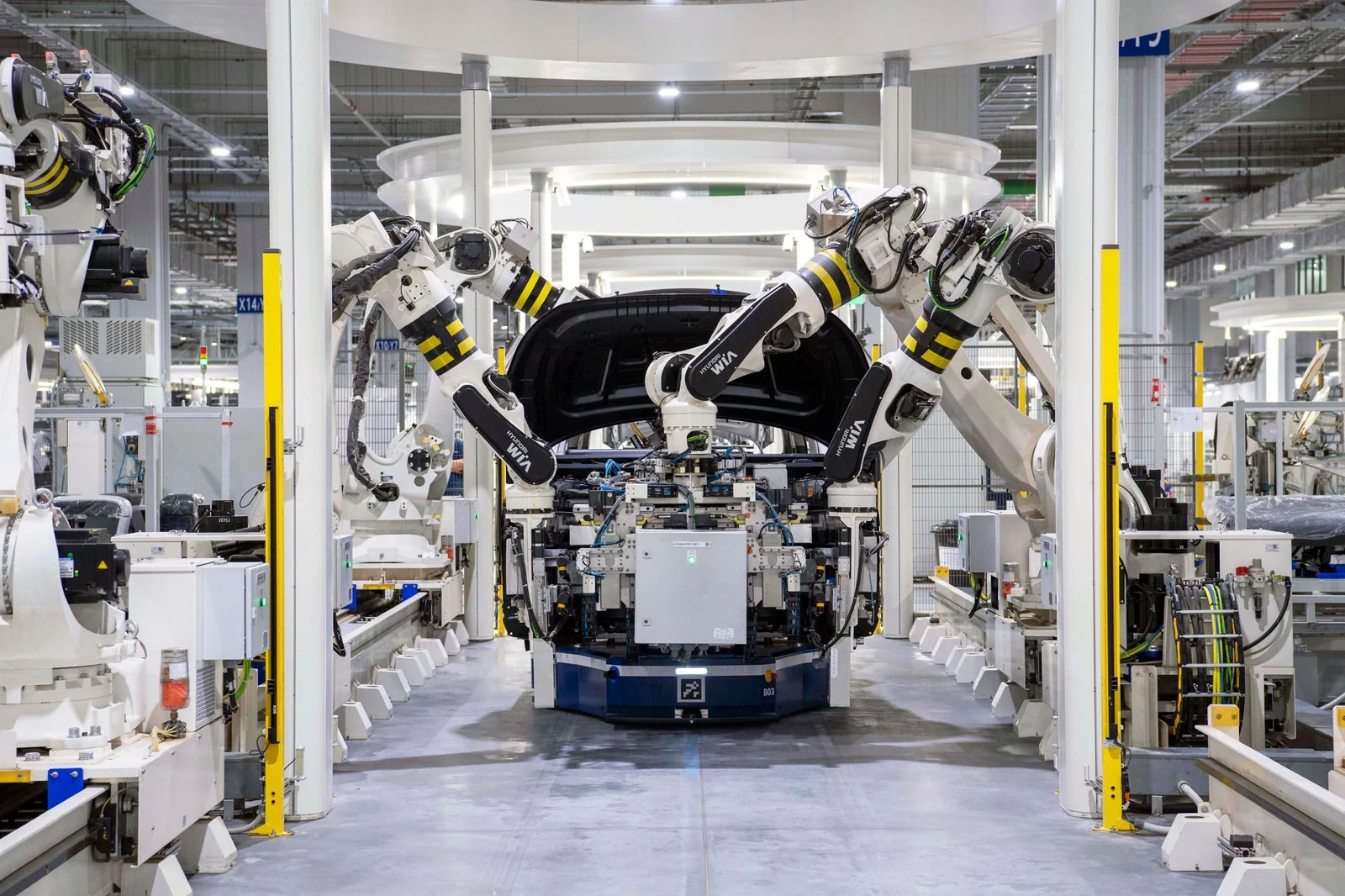 Robotic production equipment surrounds a vehicle on an automotive assembly line.