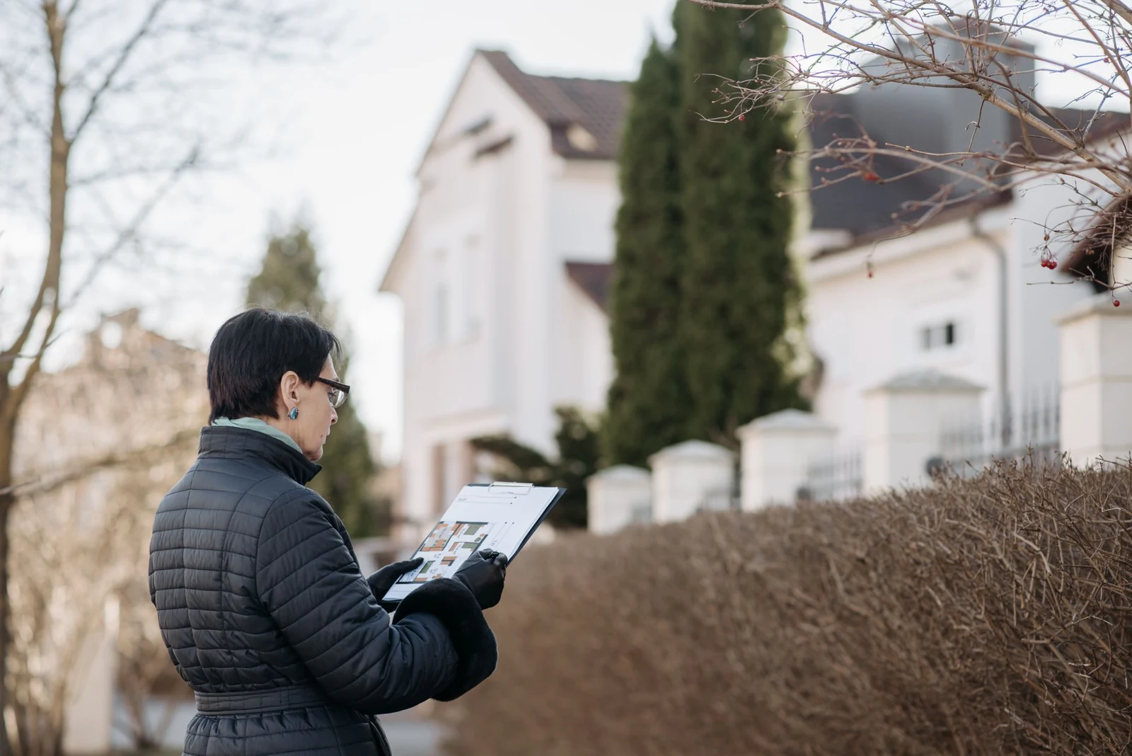 A property professional documents a house from outside.